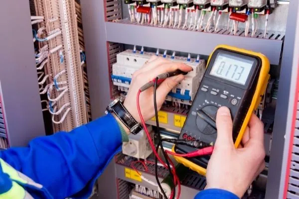 Elektricien meet in een verdeelkast met een multimeter